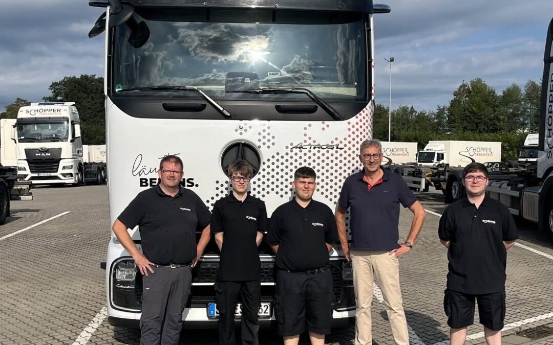 Fünf Personen stehen vor einem Lkw von Schöpper Transporte auf dem Betriebsgelände in Greven